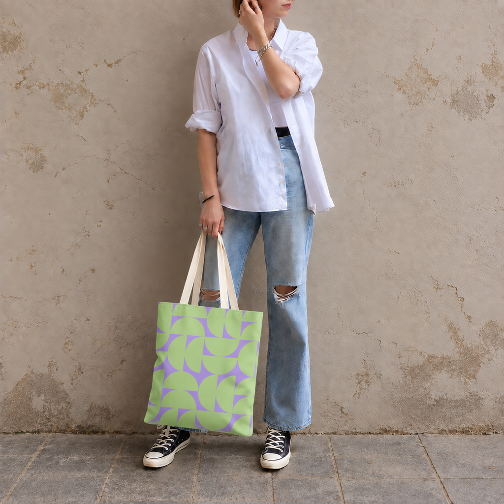 Model in jeans and a white shirt standing with the green lavender half circle tote bag