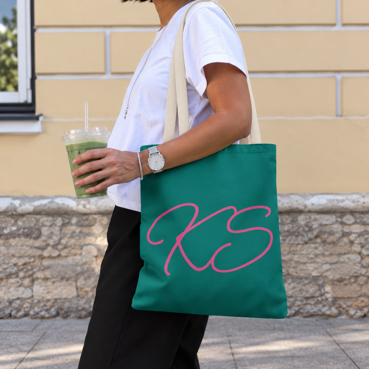 Woman carrying the Green Pink Monogram personalized tote bag, side view with an iced drink