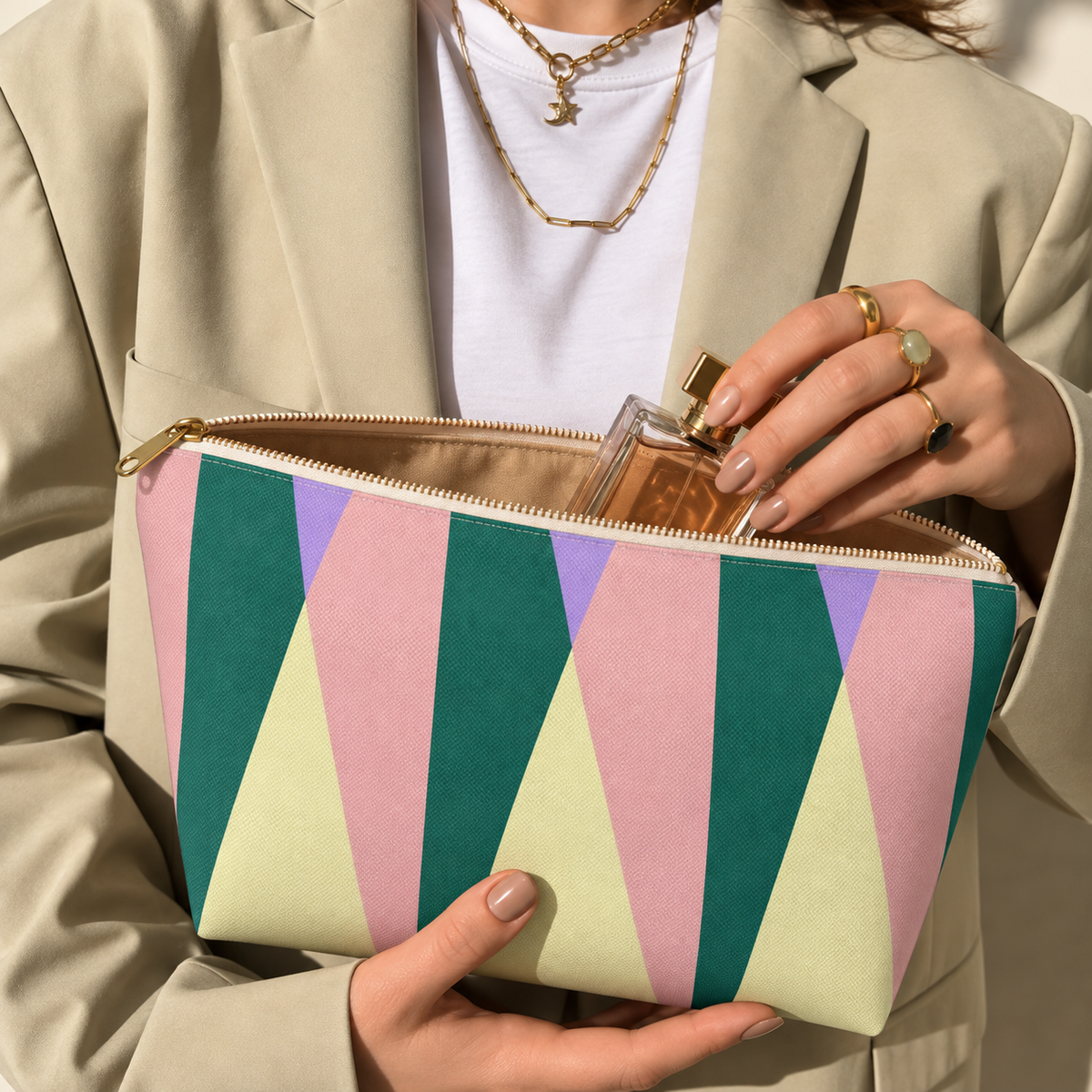 Model opening the green pink triangle makeup bag to take out a perfume bottle