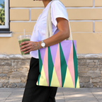 Side view of a model carrying the green pink triangle tote bag on her shoulder