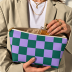 Woman holding the green purple checkered makeup bag open with the gold zipper