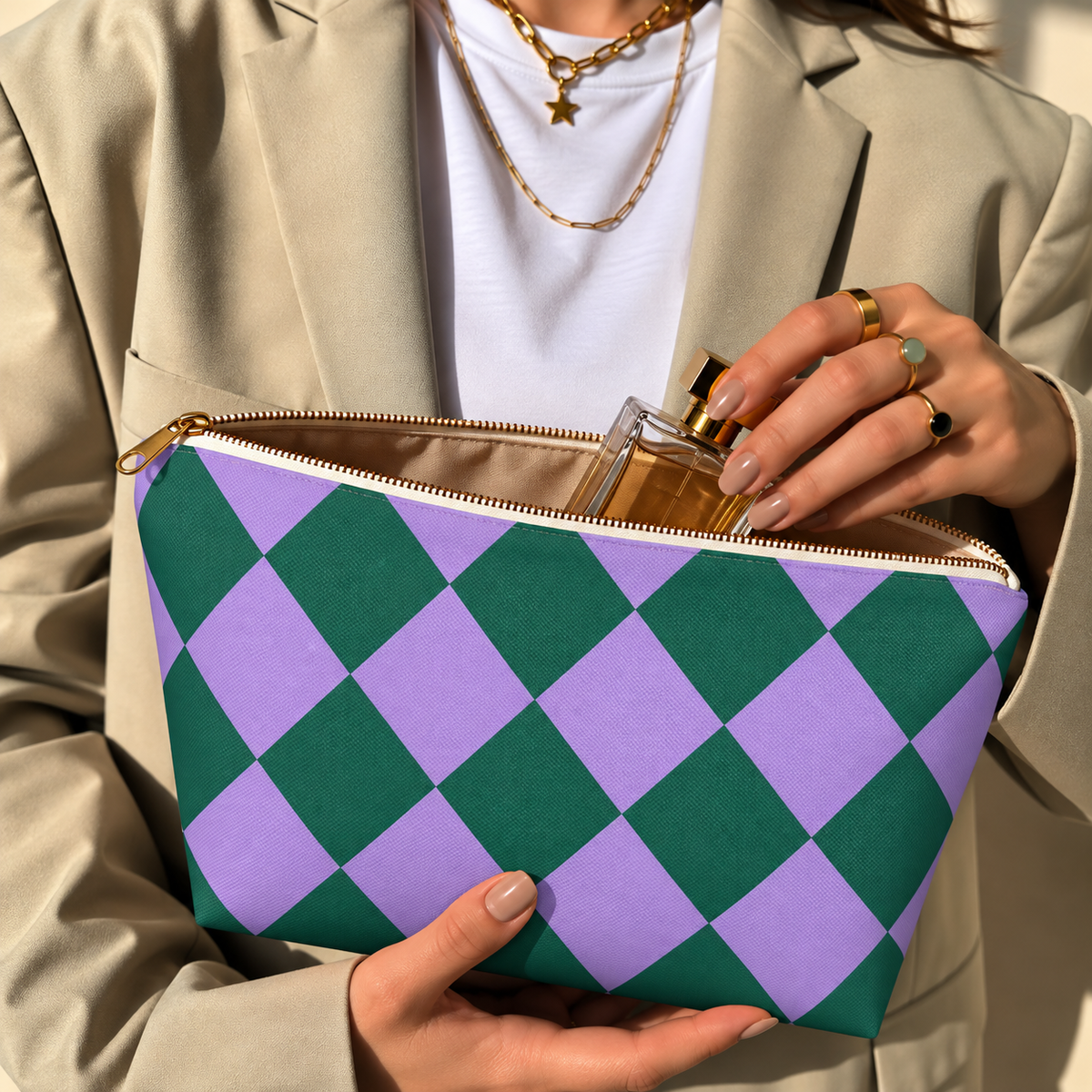 Hands holding the green purple checkered makeup bag with a perfume bottle inside