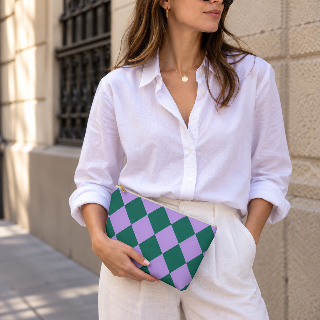 Woman in white shirt holding the green purple checkered makeup bag as a clutch