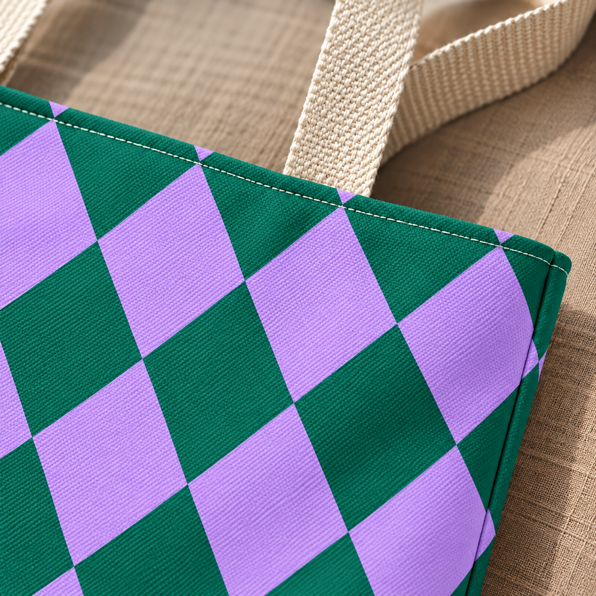 Close-up of emerald green and lilac diamond checks next to the beige tote handle