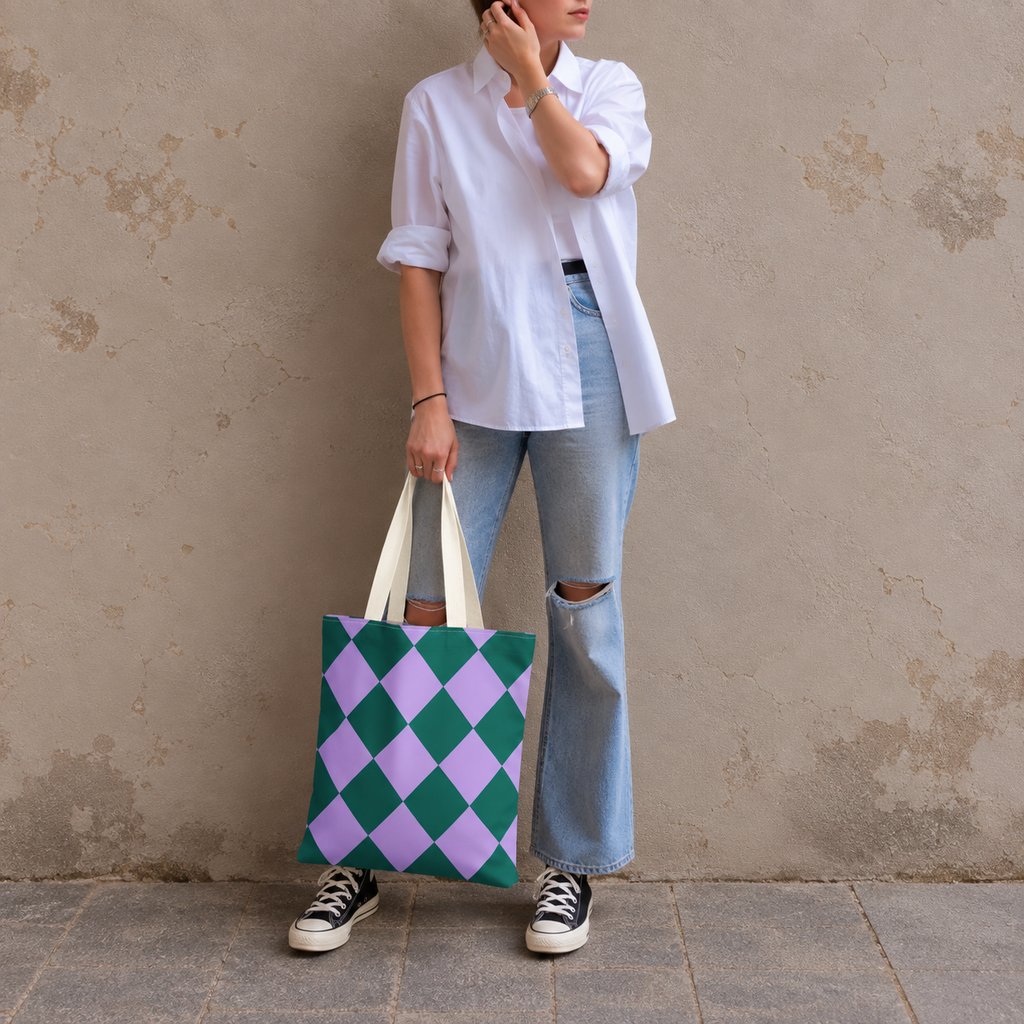 Woman in jeans and sneakers holding the green purple diamond checkered tote bag