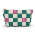 Green and cream checkered makeup bag with pink smiley faces and gold zipper pull on a white background