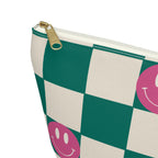 Close-up of the gold zipper pull and pink smiley face on the checkered makeup bag