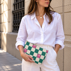 Model holding the green smiley checkered makeup bag like a clutch