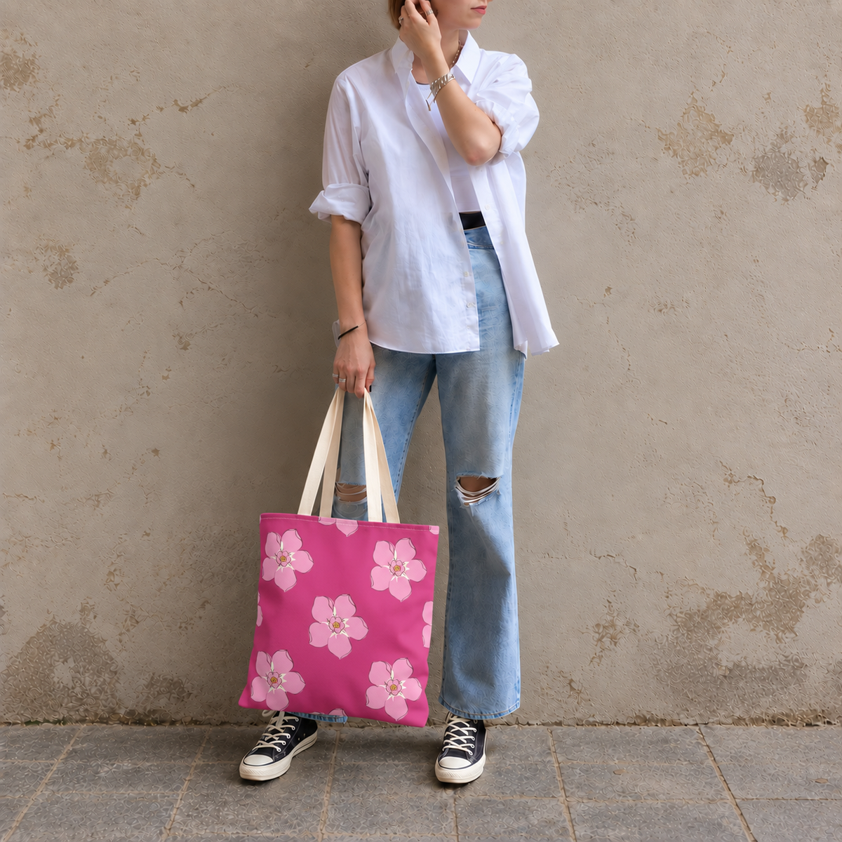 Model in jeans standing with the hot pink blossom floral tote bag