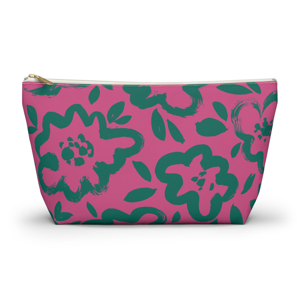 Hot pink makeup bag with green hand-drawn flowers and gold zipper pull on a white background