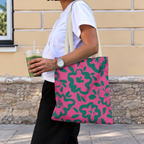 Woman with an iced drink wearing the hot pink green floral tote bag