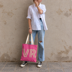 Woman in a white shirt and jeans standing with the hot pink personalized tote bag