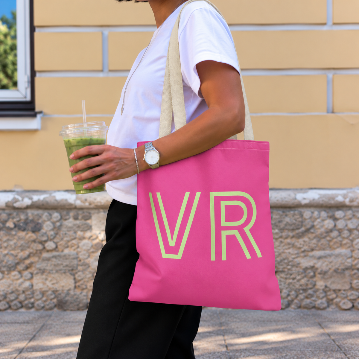 Woman with an iced drink wearing the hot pink green monogram personalized tote bag