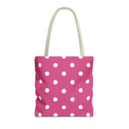 Hot pink polka dot tote bag with white dots and cream handles on a white background