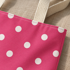 Close-up of the white polka dots on hot pink fabric and the handle of the tote bag
