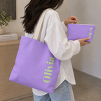 Woman carrying the Lavender Green Name personalized tote bag on her shoulder with the matching makeup bag
