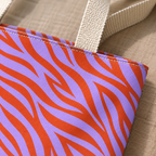 Close-up of the orange zebra stripes on lavender fabric and the handle of the tote bag