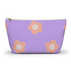 Lavender makeup bag with peach daisies and gold zipper pull on a white background
