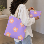 Woman carrying the daisy tote bag with the matching lavender makeup bag