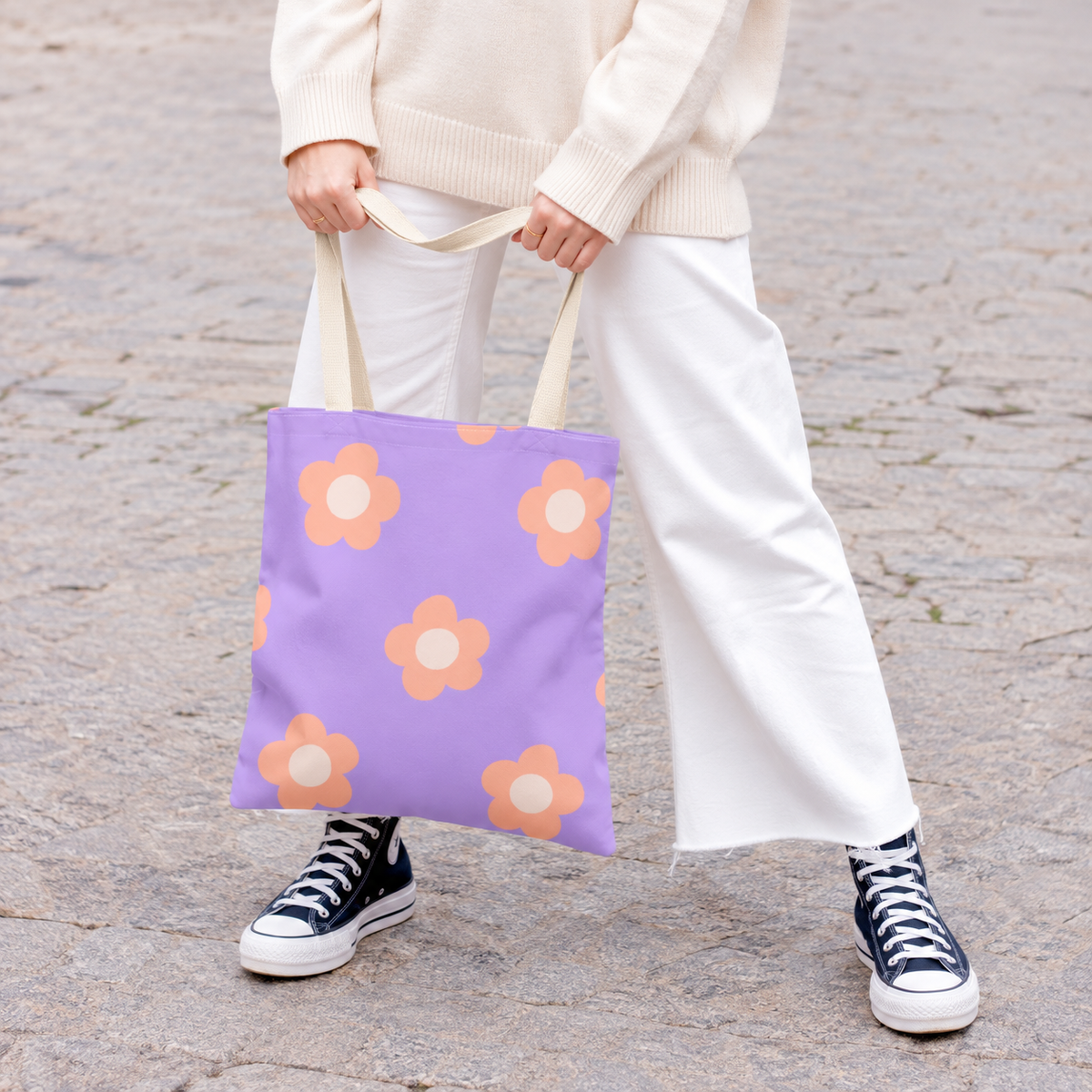 Model holding the lavender peach daisy tote bag by its handles