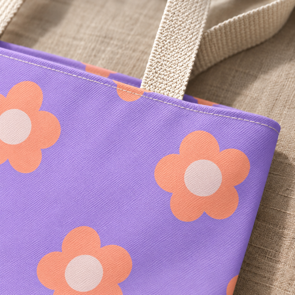 Close-up of the peach daisy print on lavender and the cream handle of the tote bag
