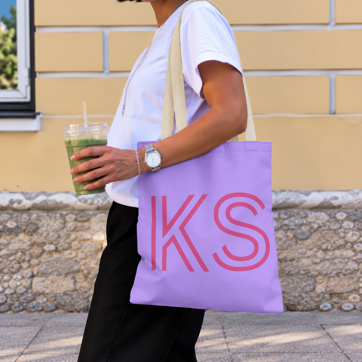 Woman with an iced drink wearing the lavender pink monogram personalized tote bag