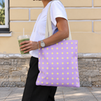 Woman walking with the lavender yellow polka dot tote bag on her shoulder and an iced drink