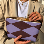 Model in a beige blazer taking a product out of the open lilac burgundy diamond makeup bag