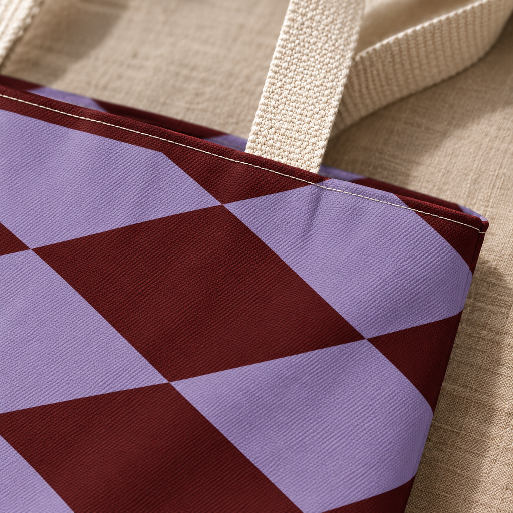 Close-up of the lilac and burgundy diamond print and beige handle on the tote bag