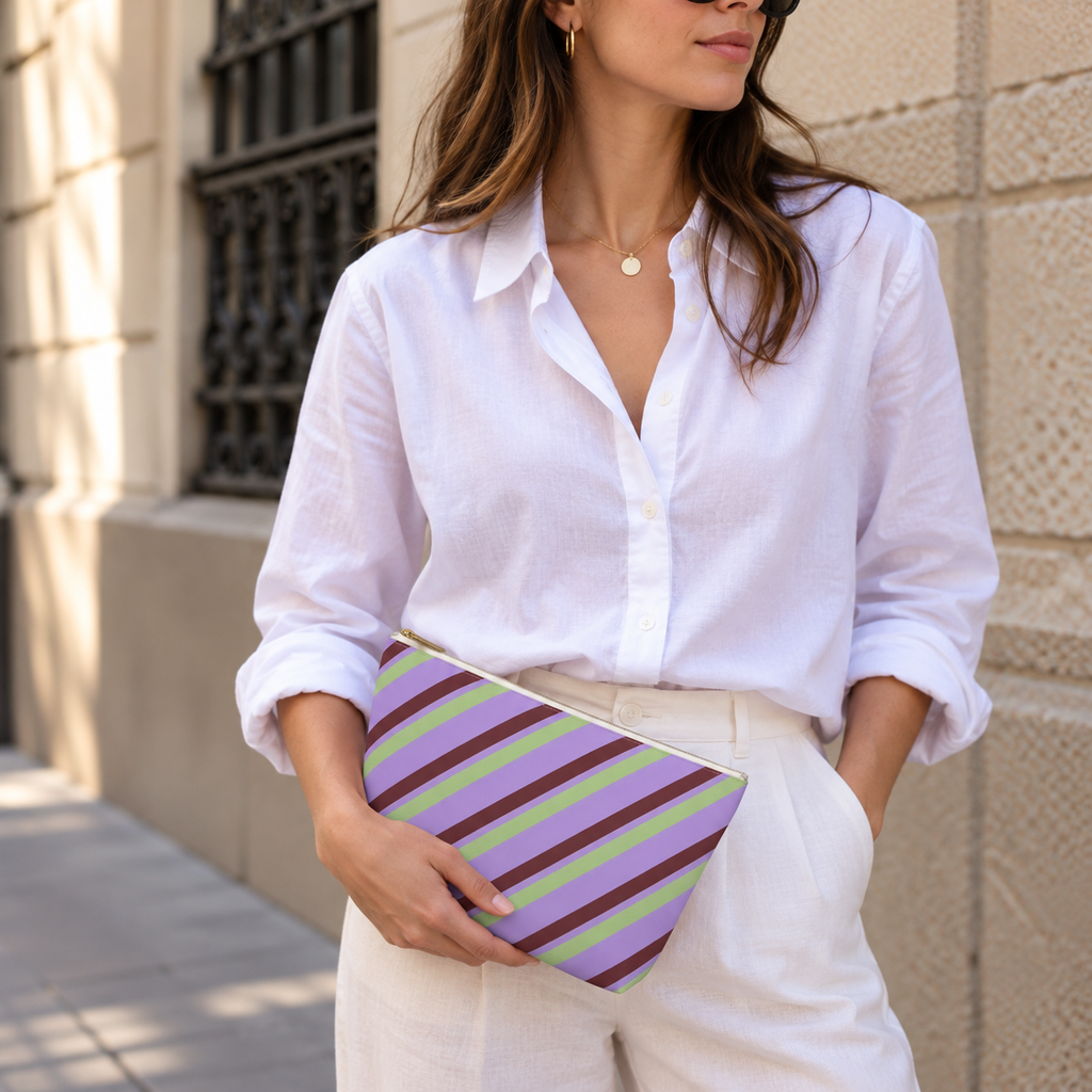 Woman in a white shirt holding the lilac striped makeup bag as a clutch