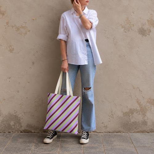 Woman in a white shirt and jeans holding the lilac diagonal striped tote bag
