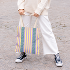 Model in white trousers carrying the Lilac Leopard Striped tote bag with blue leopard panel