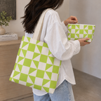 Woman carrying the matching tote bag and holding the lime green cream geometric makeup bag