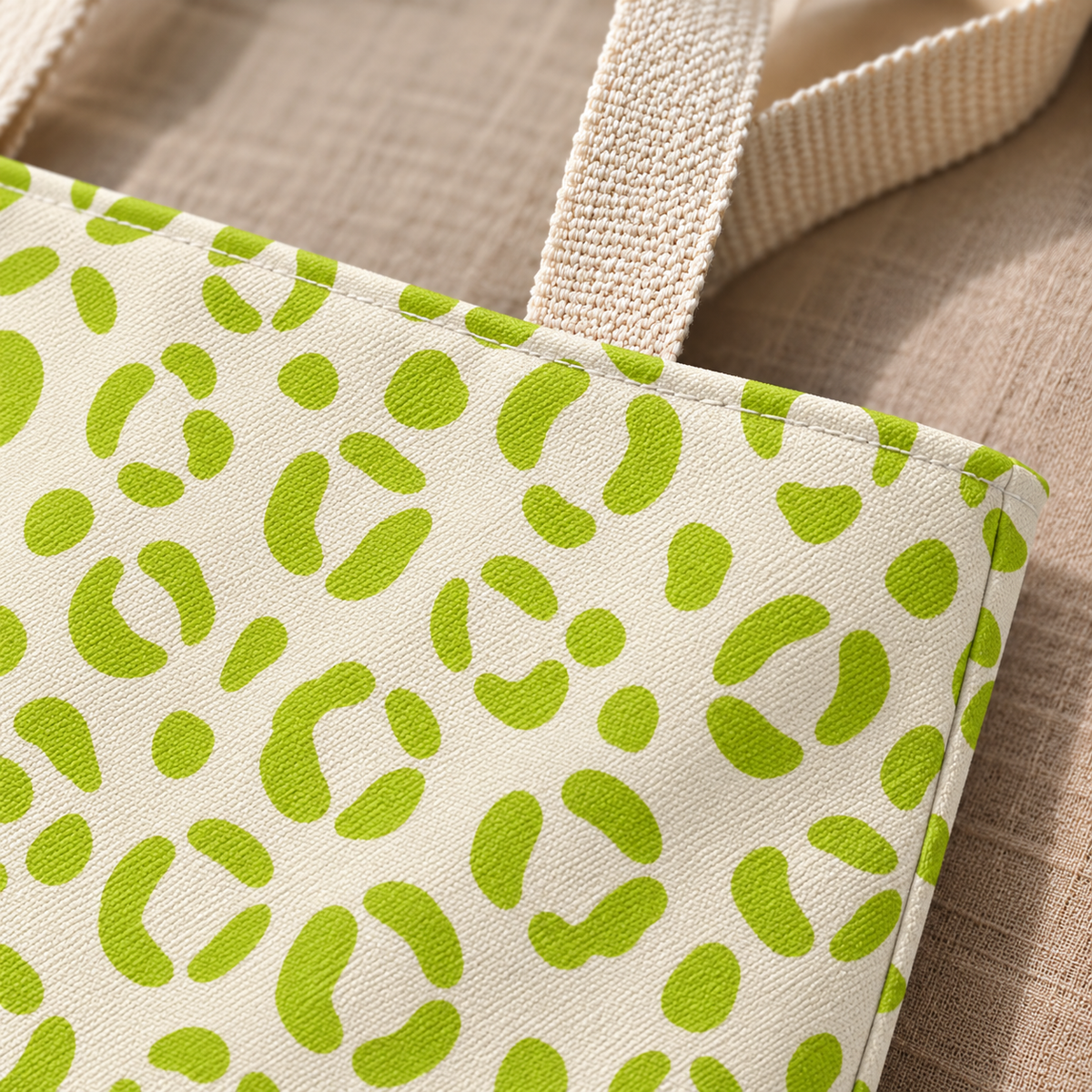 Close-up of the lime green leopard spots on cream and the beige tote handle