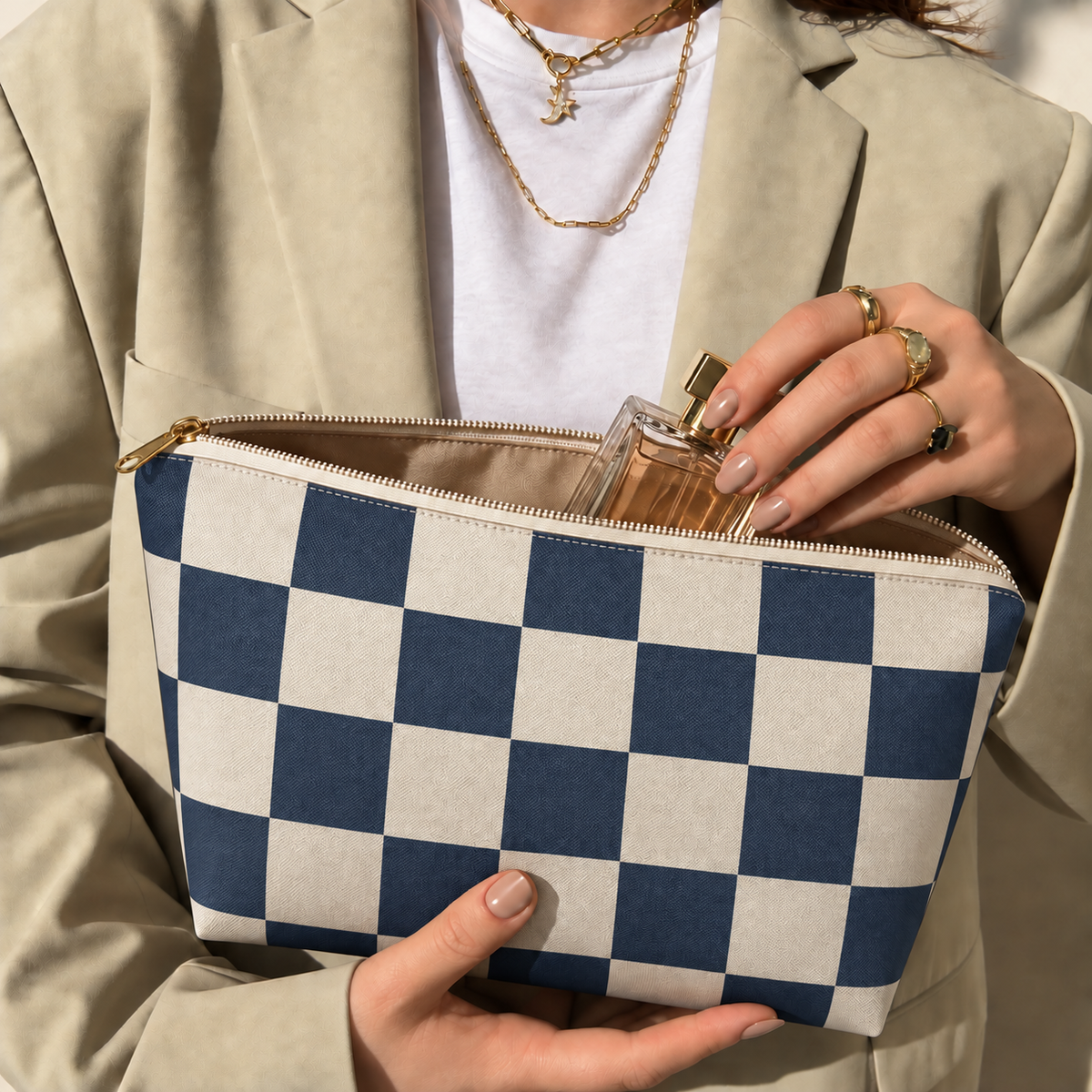 Hands holding the open navy cream checkered makeup bag