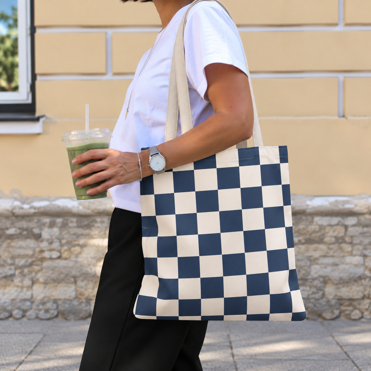 Side view of a person carrying the navy cream checkered tote bag on the shoulder