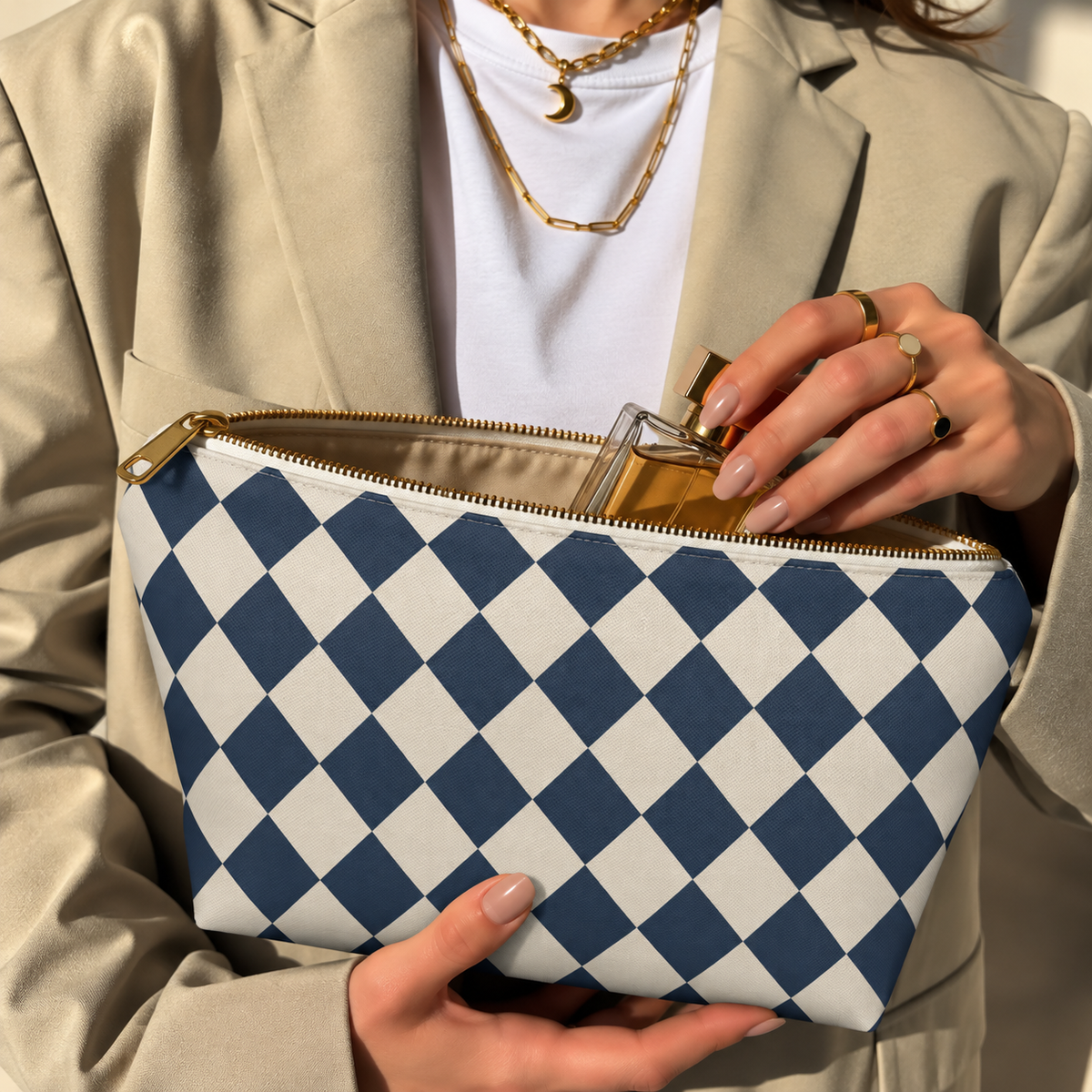 Hands opening a navy cream diamond checkered makeup bag filled with cosmetics