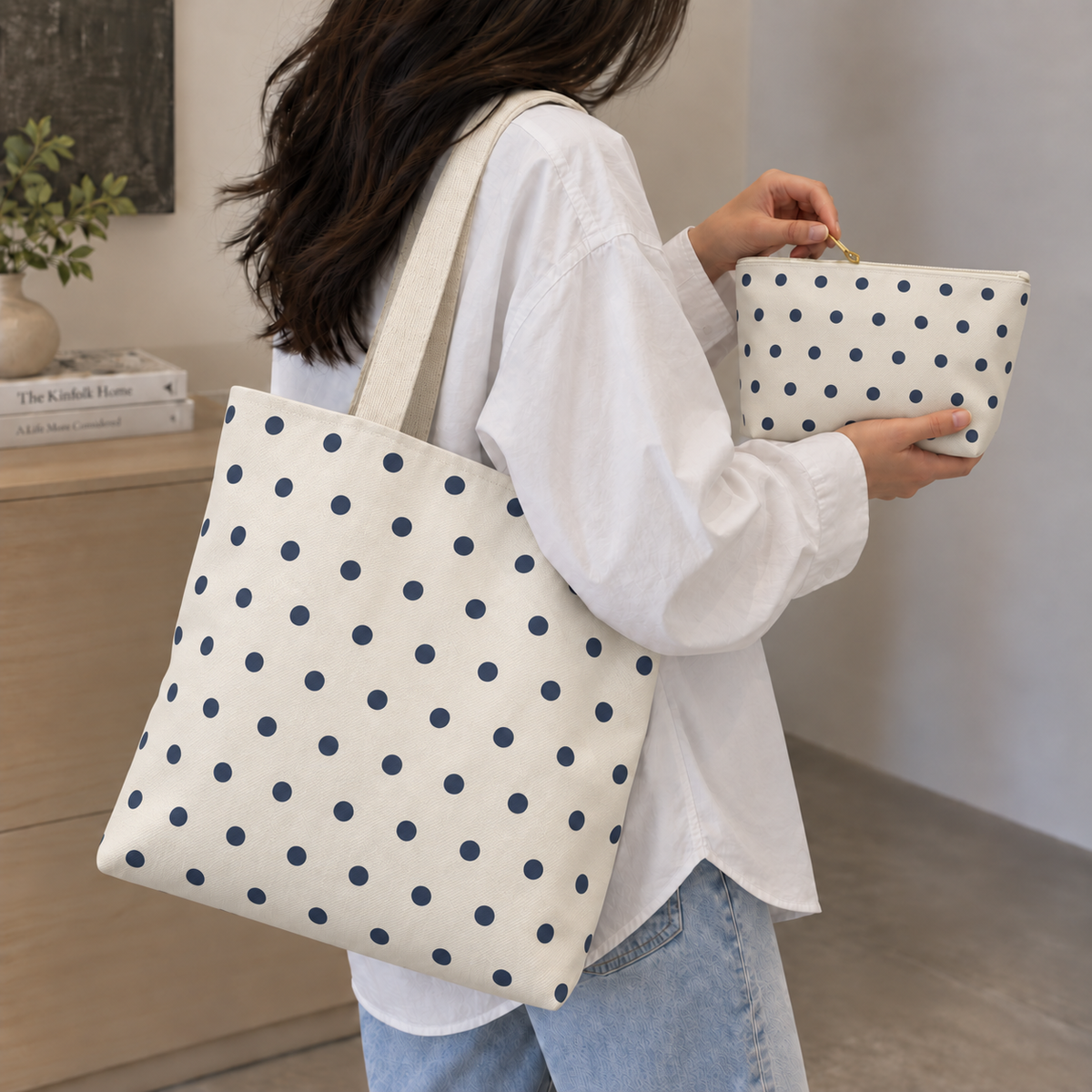 Model carrying the polka dot tote bag while holding the matching navy cream makeup bag