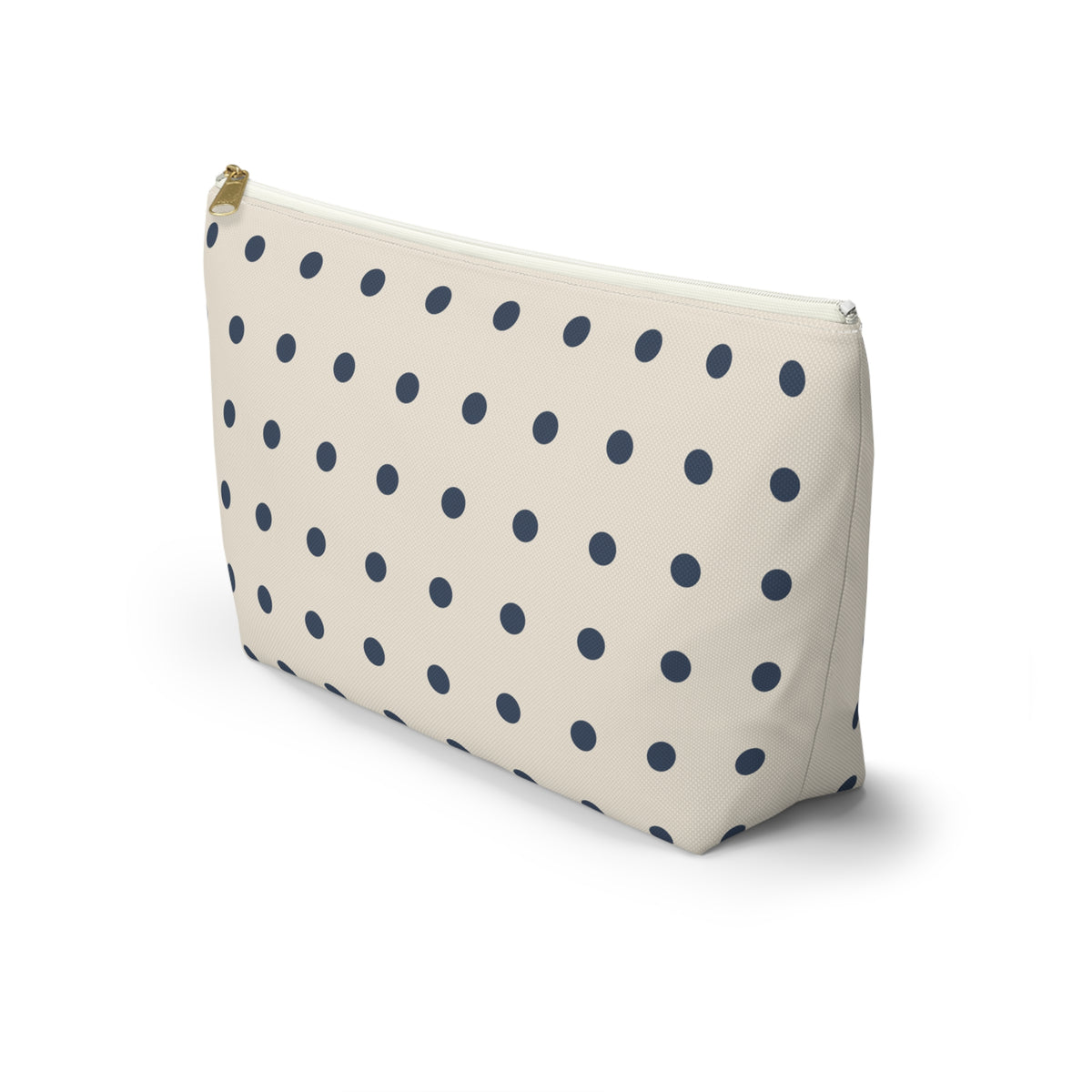 Side view of the navy cream polka dot makeup bag standing upright