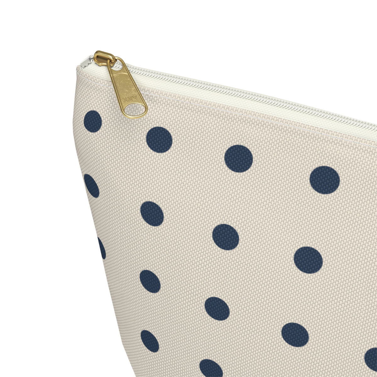 Close-up of the gold zipper pull on the navy cream polka dot makeup bag