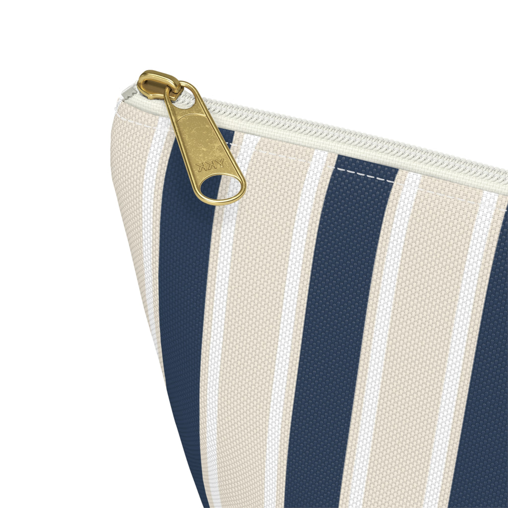 Close-up of the gold zipper pull and navy stripe on the makeup bag