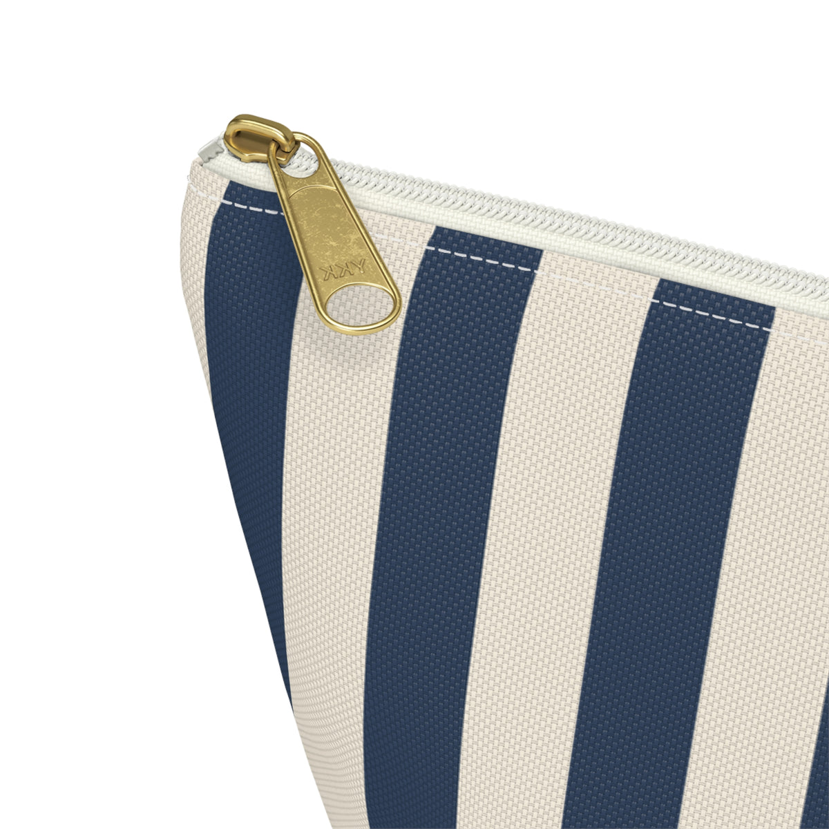 Close-up of the gold zipper pull and navy stripes on the makeup bag