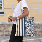 Woman with a navy cream striped tote bag with zebra print panel over her shoulder
