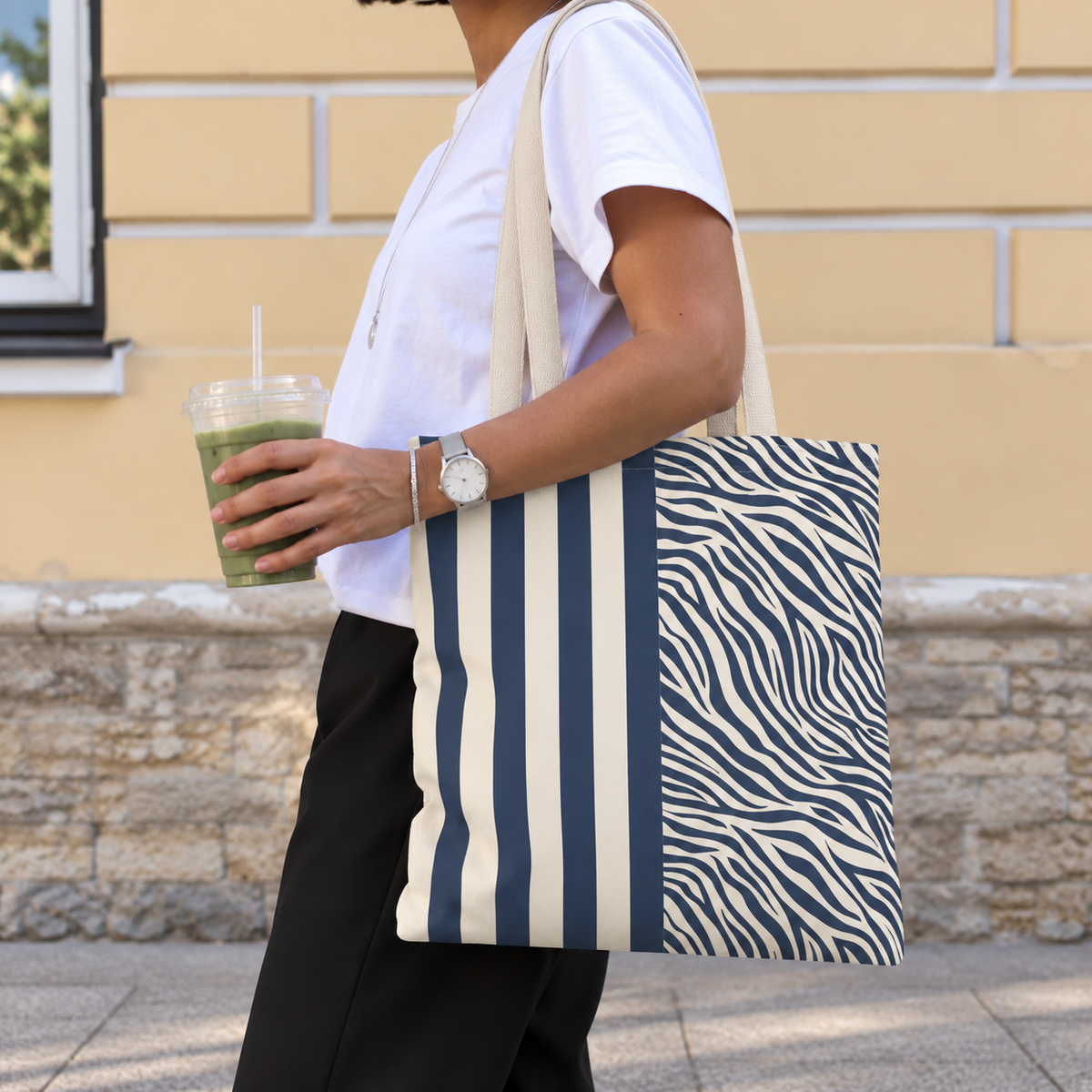 Woman with a navy cream striped tote bag with zebra print panel over her shoulder