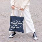 Model holding the Navy White Monogram personalized tote bag in front of white trousers