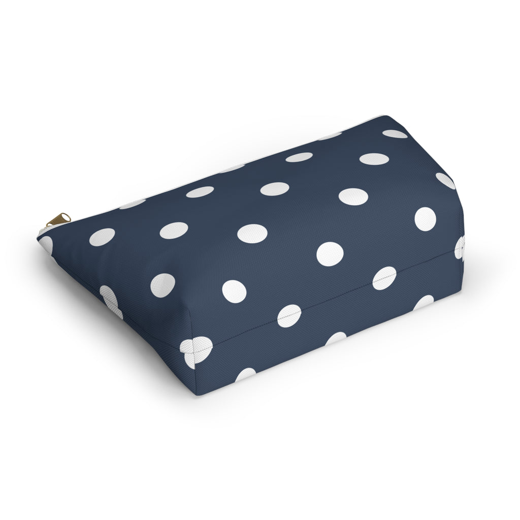 Navy cosmetic bag with white polka dots lying at an angle