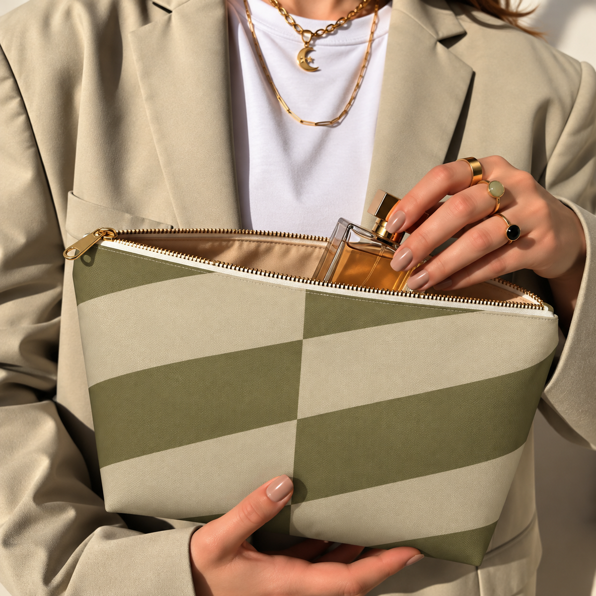 Model in a beige blazer taking a product out of the open olive beige geometric makeup bag