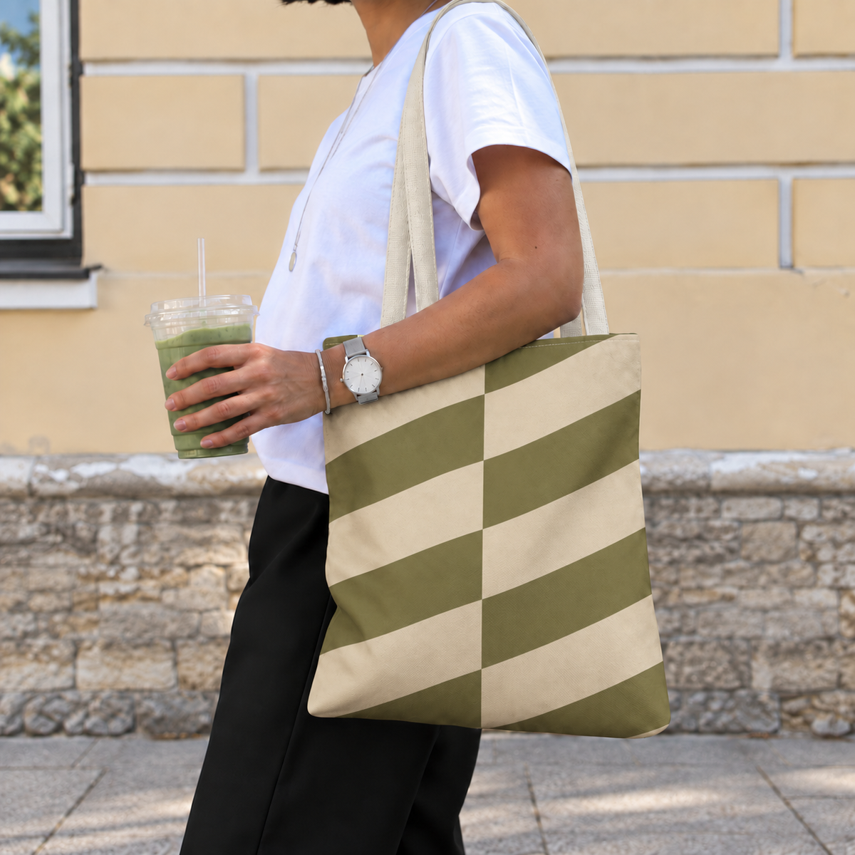 Side view of a model carrying the olive beige geometric tote bag on the shoulder