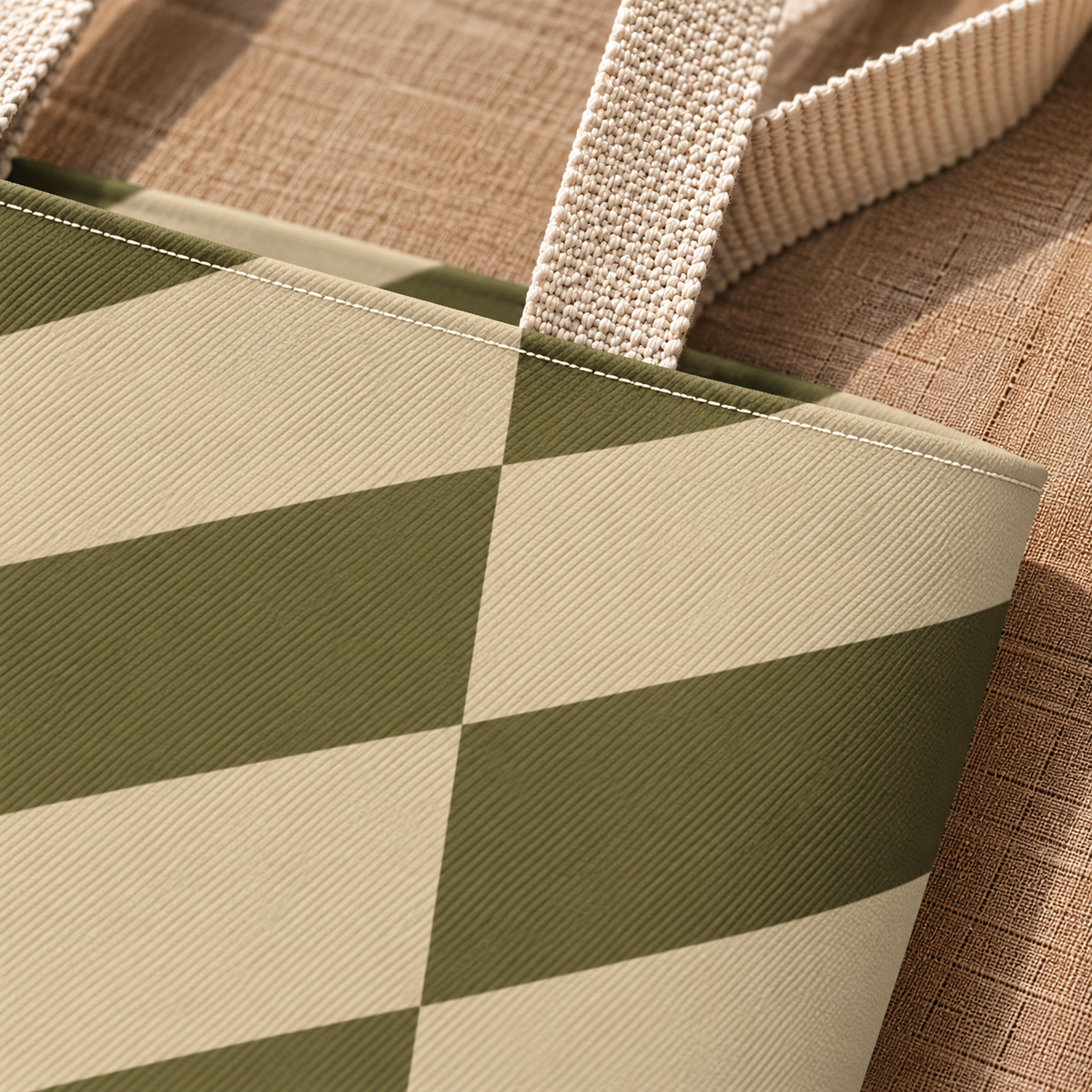 Close-up of the olive green and beige block print and beige handle on the tote bag