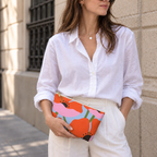 Model holding the orange poppy floral makeup bag like a clutch